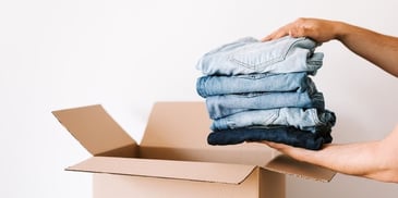 hands-placing-denim-in-box