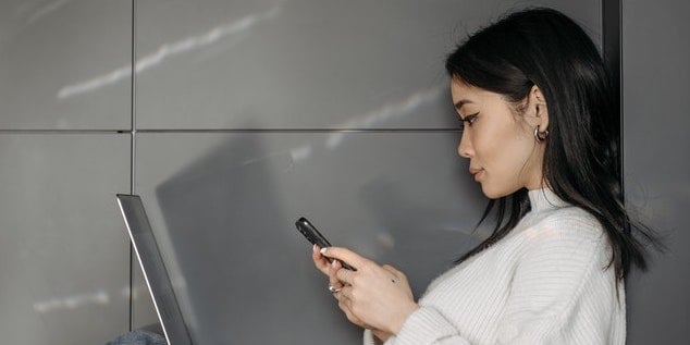 person-looking-at-phone-and-computer