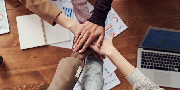 hand-pile-up-across-business-meeting