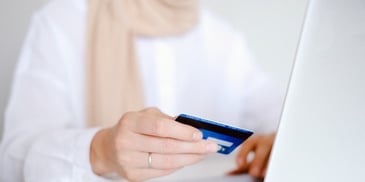 holding-credit-card-by-computer