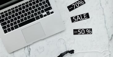 retail-sale-tags-near-hanger-and-macbook